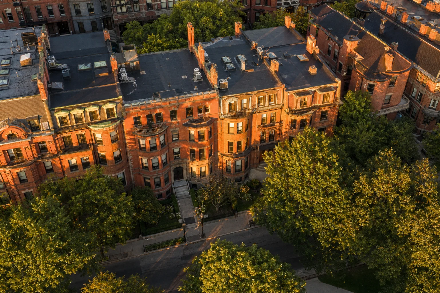 Outsourced accounting services for property management companies in Boston with aerial view of Boston brownstone apartment buildings at golden hour